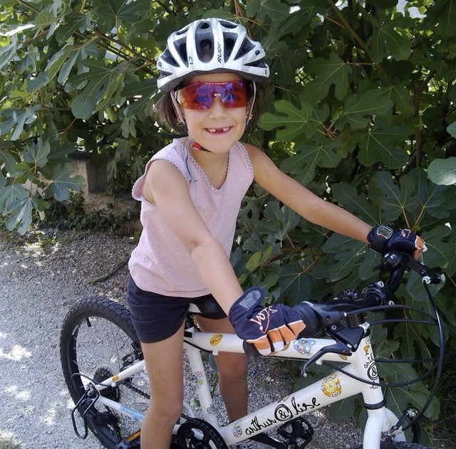 Jeune Capucine enfant sur un VTT lors de ses débuts en cyclisme