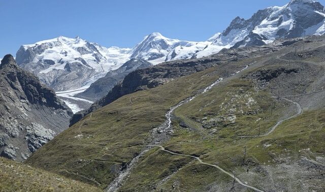 Paysage des Alpes suisses entre montagne verdoyante et sommets enneigés